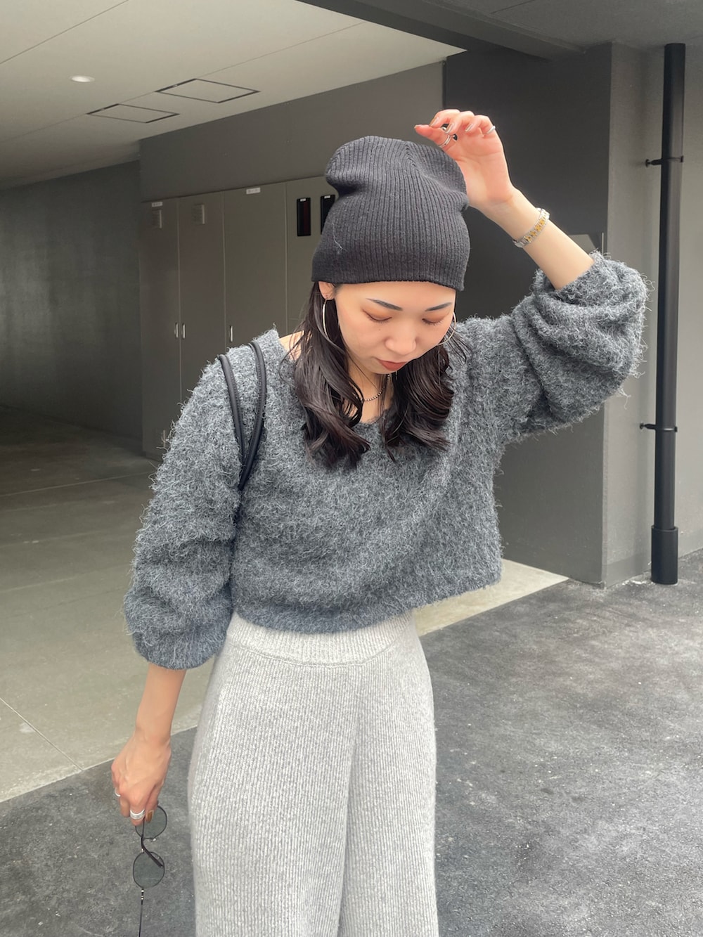 グレー系のニット/セーター、グレー系のその他パンツ、ブラック系のハンドバッグを着用したレディースの秋コーディネートの4枚目の写真