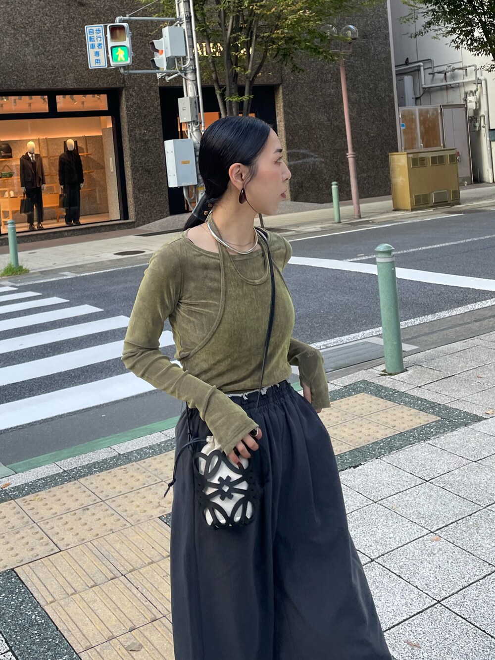 グレー系のその他パンツ、グリーン系のTシャツ/カットソー、ゴールド系のパンプスを着用したレディースの秋コーディネートの4枚目の写真