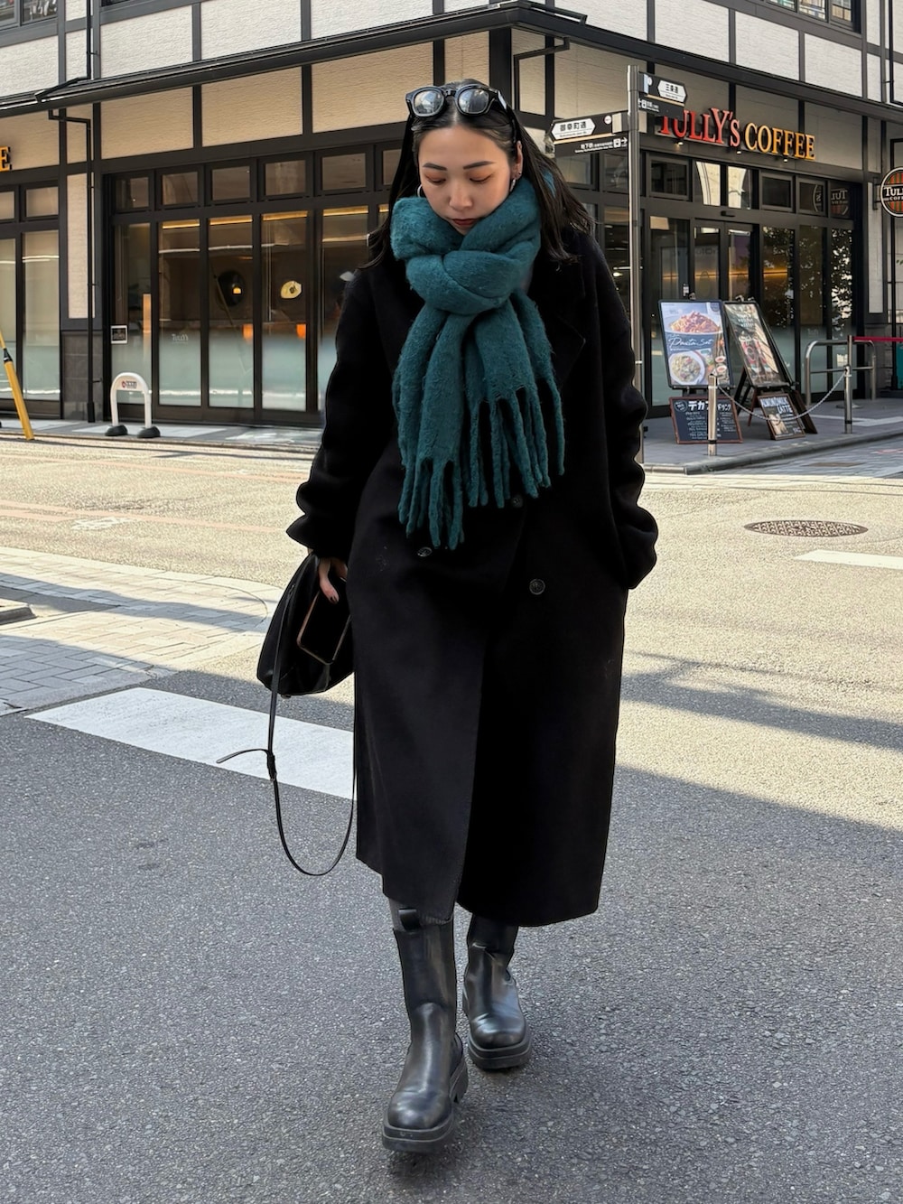 ブラック系のブーツ、ブラック系のショルダーバッグを着用したレディースの秋コーディネートの2枚目の写真