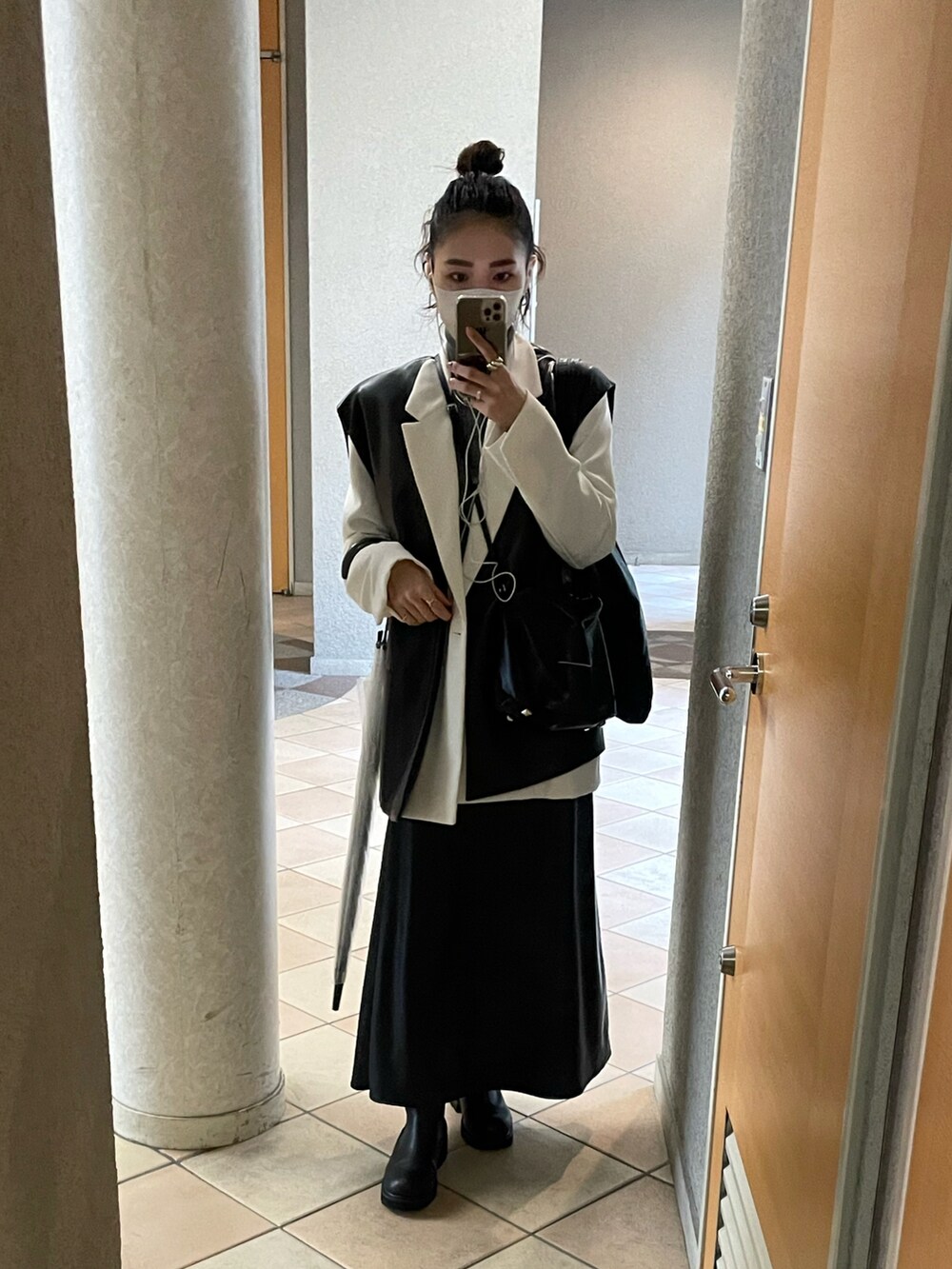 ホワイト系のテーラードジャケット、ブラック系のショルダーバッグ、ブラック系のスカートを着用したレディースの秋コーディネートの2枚目の写真