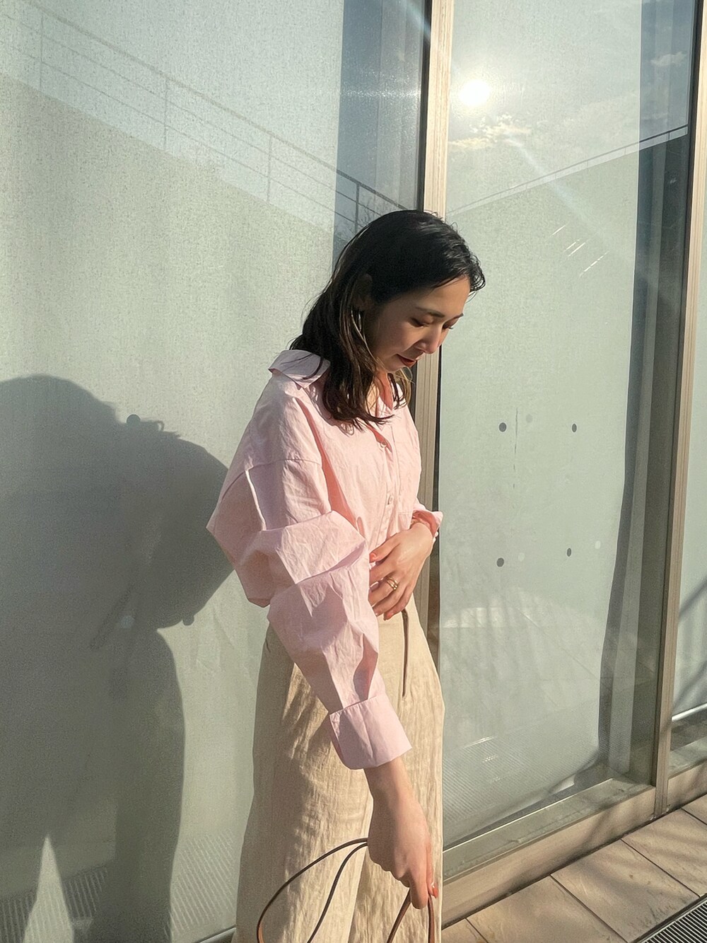 ピンク系のシャツ/ブラウス、ブラウン系のショルダーバッグ、ホワイト系のサンダルを着用したレディースの春コーディネートの4枚目の写真