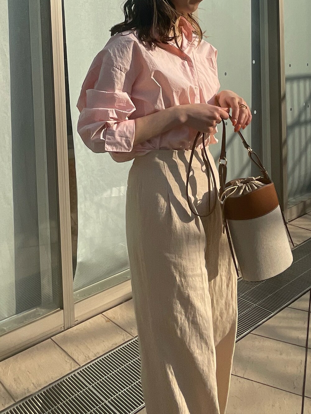 ピンク系のシャツ/ブラウス、ブラウン系のショルダーバッグ、ホワイト系のサンダルを着用したレディースの春コーディネートの3枚目の写真