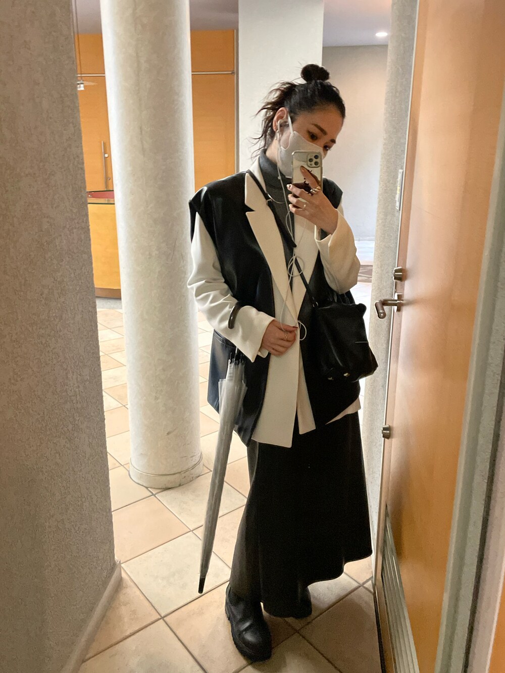 ホワイト系のテーラードジャケット、ブラック系のショルダーバッグ、ブラック系のスカートを着用したレディースの秋コーディネートの4枚目の写真