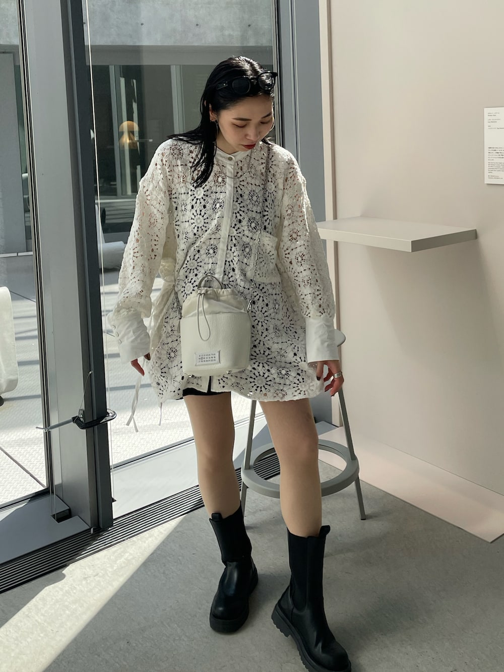 ブラック系のブーツ、ホワイト系のシャツ/ブラウス、ホワイト系のショルダーバッグを着用したレディースの春コーディネートの5枚目の写真