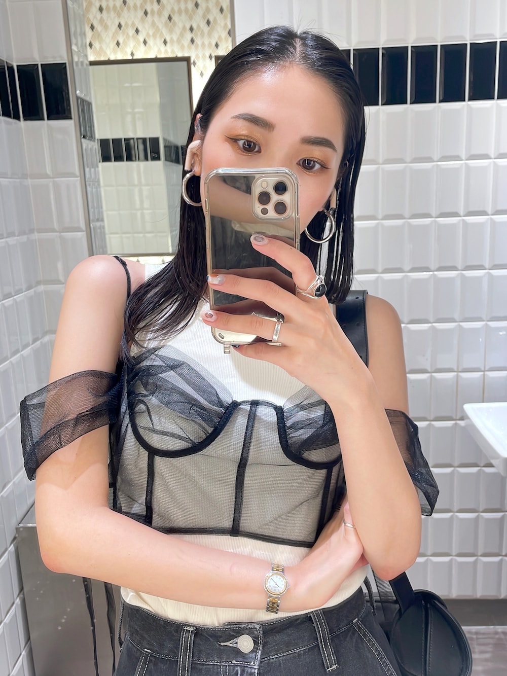 ゴールド系のパンプス、ブラック系のデニムパンツ、ブラック系のショルダーバッグを着用したレディースの秋コーディネートの5枚目の写真