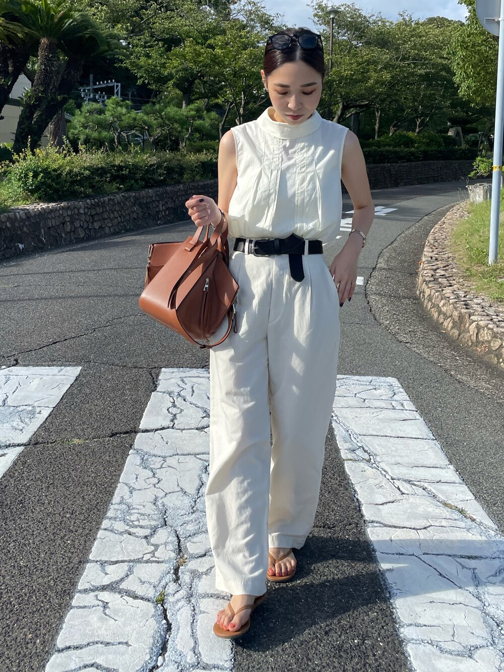 ブラウン系のバックパック/リュック、ホワイト系のシャツ/ブラウス、ブラウン系のサンダルを着用したレディースの夏コーディネートの4枚目の写真