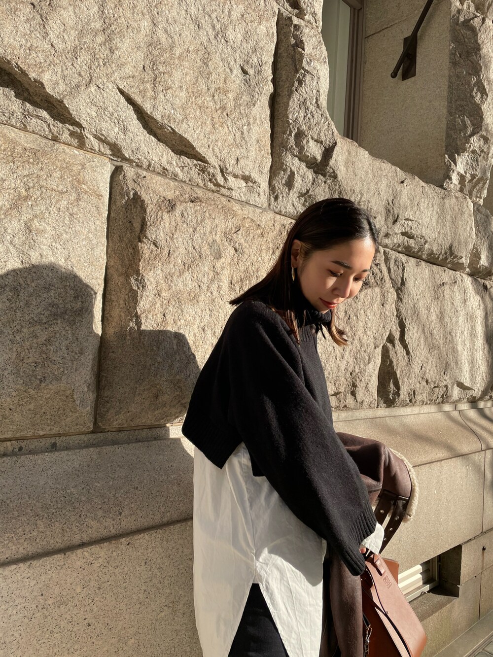 ブラック系のブーツ、ホワイト系のシャツ/ブラウス、ブラック系のニット/セーターを着用したレディースの冬コーディネートの3枚目の写真