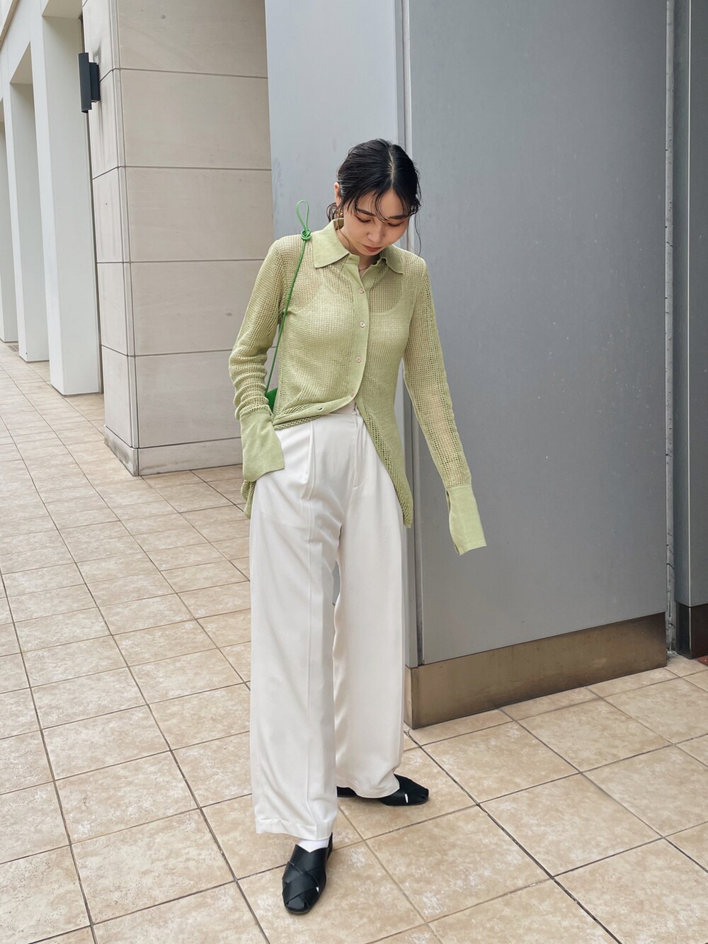 グリーン系のニット/セーター、ホワイト系のキャミソール、ホワイト系のその他パンツを着用したレディースの春コーディネートの3枚目の写真