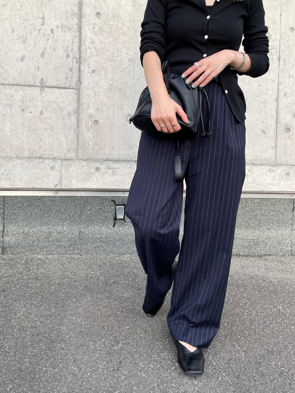 ブラック系のカーディガン/ボレロ、ブラック系のハンドバッグ、その他のスラックスを着用したレディースの秋コーディネートの5枚目の写真