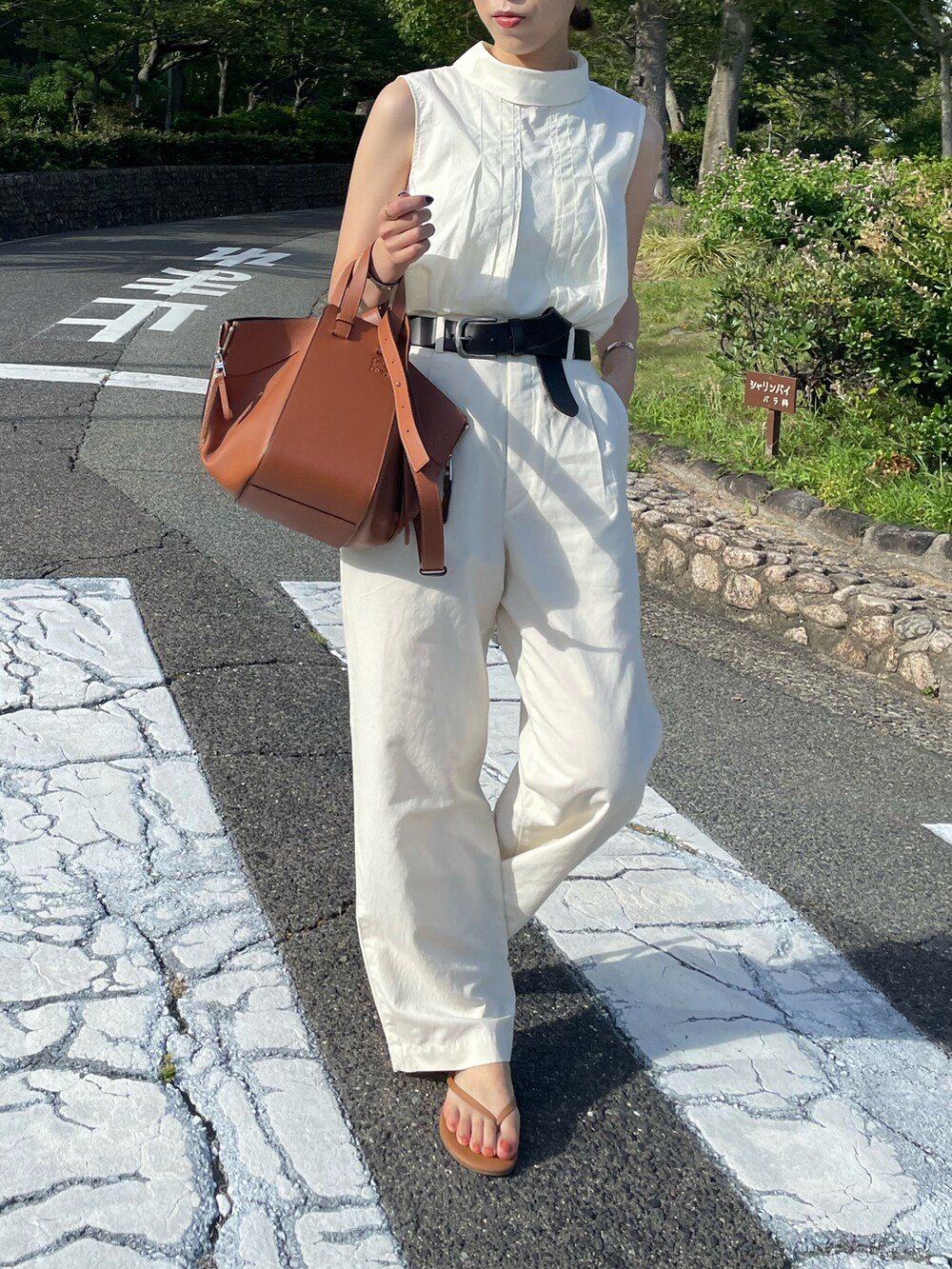 ブラウン系のバックパック/リュック、ホワイト系のシャツ/ブラウス、ブラウン系のサンダルを着用したレディースの夏コーディネートの2枚目の写真