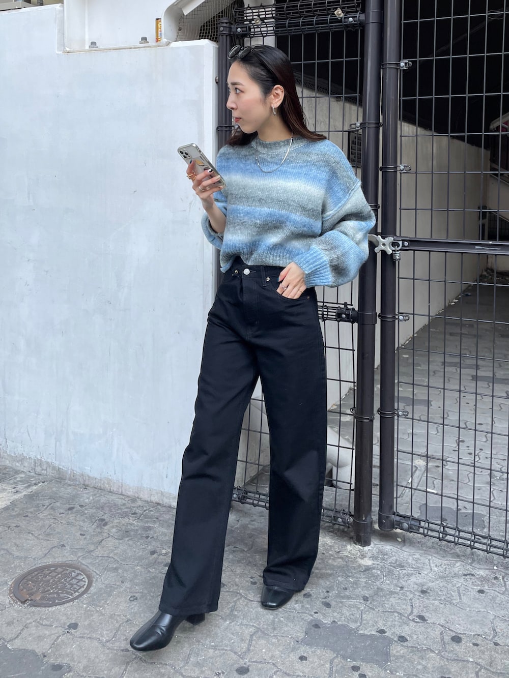 ブラック系のデニムパンツ、ブルー系のニット/セーターを着用したレディースの秋コーディネートの3枚目の写真