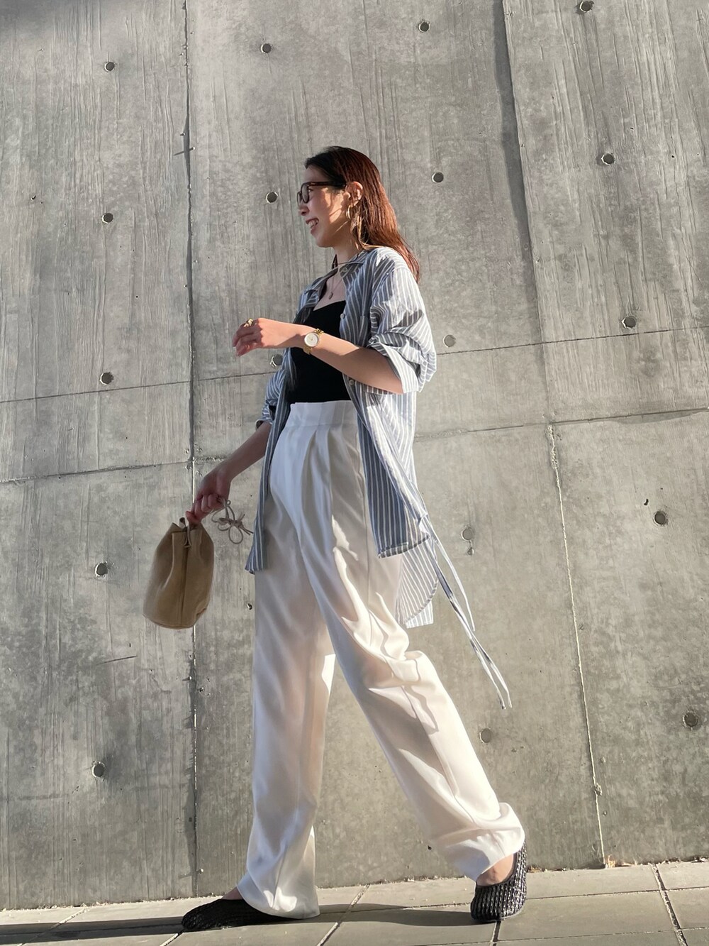 ブラック系のキャミソール、ブルー系のシャツ/ブラウス、ベージュ系のハンドバッグを着用したレディースの春コーディネートの3枚目の写真