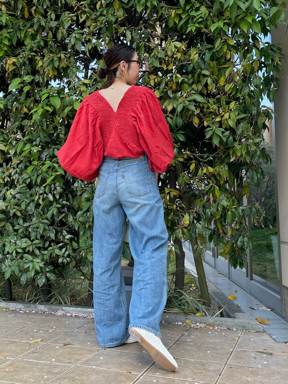 レッド系のシャツ/ブラウス、ブルー系のデニムパンツ、ホワイト系のパンプスを着用したレディースの春コーディネートの4枚目の写真