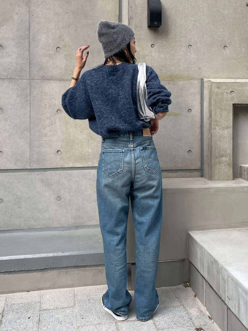 ブルー系のニット/セーター、ブルー系のデニムパンツ、ブラック系のスニーカーを着用したレディースの秋コーディネートの2枚目の写真