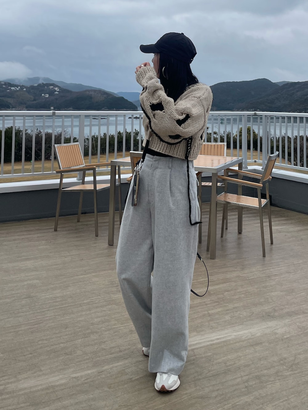 ホワイト系のニット/セーター、グレー系のその他パンツ、ブラック系のショルダーバッグを着用したレディースの冬コーディネートの3枚目の写真