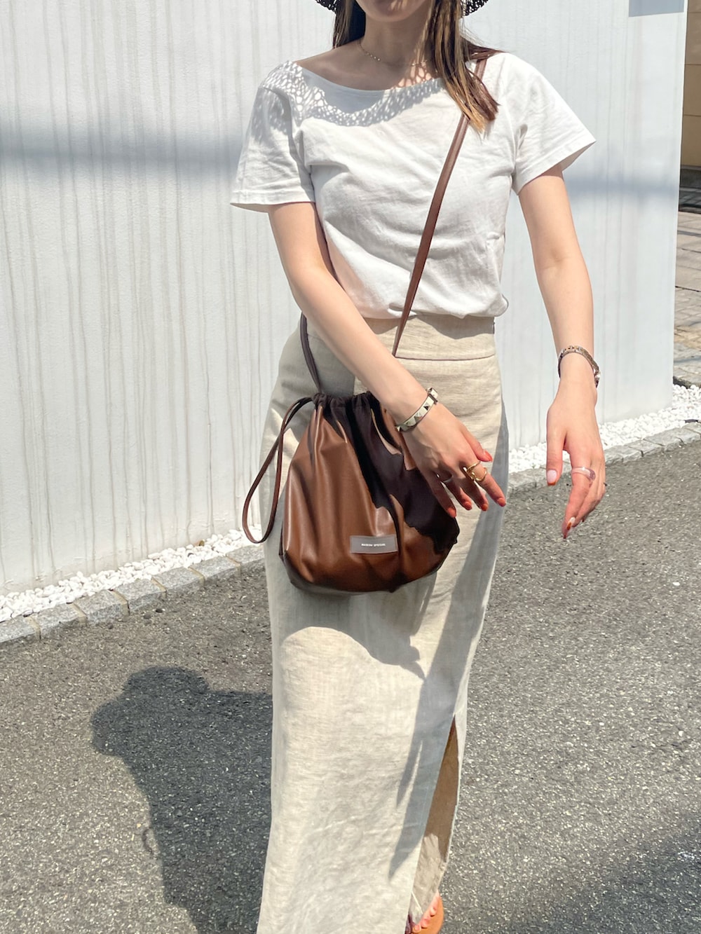ホワイト系のTシャツ/カットソー、ブラウン系のショルダーバッグ、ブラウン系のサンダルを着用したレディースの夏コーディネートの4枚目の写真