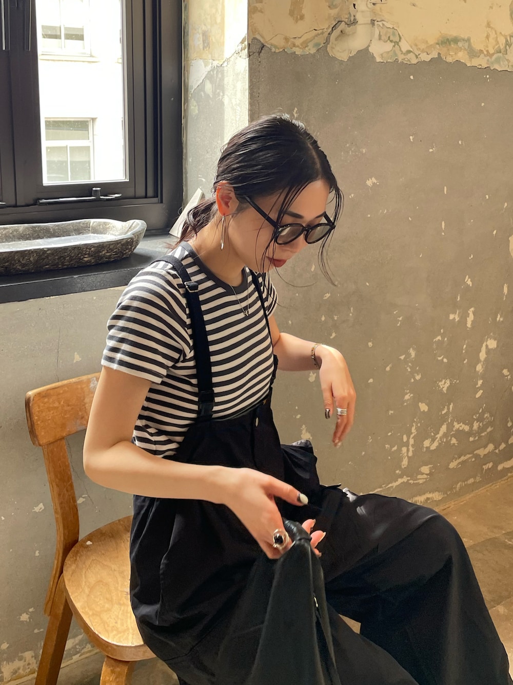 ブラック系のサロペット/オーバーオール、グレー系のTシャツ/カットソー、ホワイト系のスニーカーを着用したレディースの春コーディネートの5枚目の写真