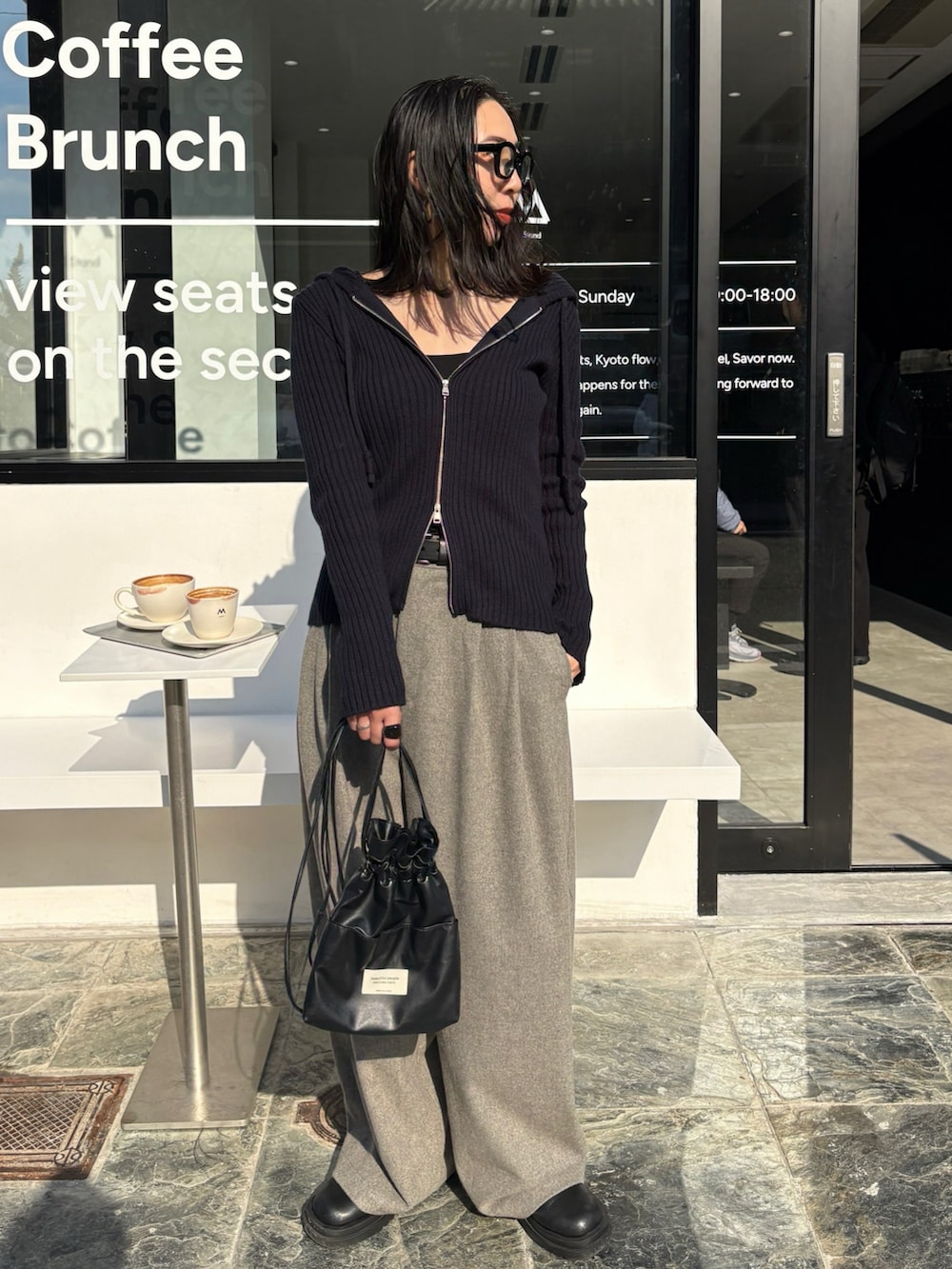 ブラック系のショルダーバッグ、ブラック系のブーツを着用したレディースの秋コーディネートの2枚目の写真