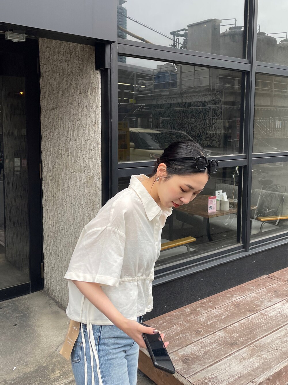 ブルー系のデニムパンツ、ゴールド系のサンダル、ホワイト系のシャツ/ブラウスを着用したレディースの春コーディネートの4枚目の写真