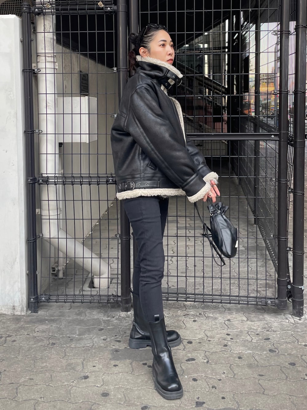 ブラック系のショルダーバッグ、ブラック系のデニムパンツ、シルバー系のニット/セーターを着用したレディースの秋コーディネートの3枚目の写真