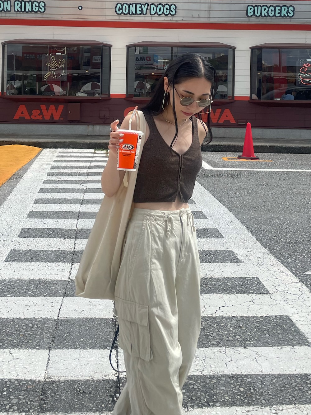 ホワイト系のカーゴパンツ、ブラック系のサンダル、ブラック系のショルダーバッグを着用したレディースの秋コーディネートの3枚目の写真