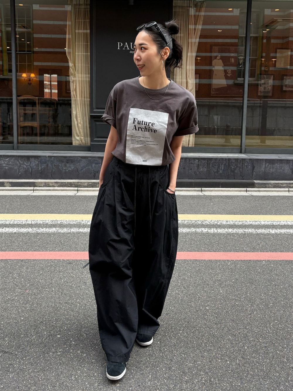 ブラック系のスニーカーを着用したレディースの春コーディネートの2枚目の写真