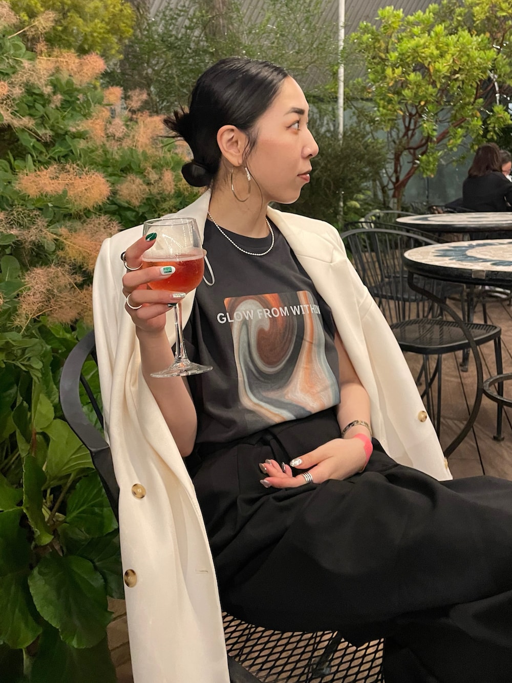 ブラック系のスラックス、ブラック系のサンダル、ホワイト系のテーラードジャケットを着用したレディースの夏コーディネートの4枚目の写真