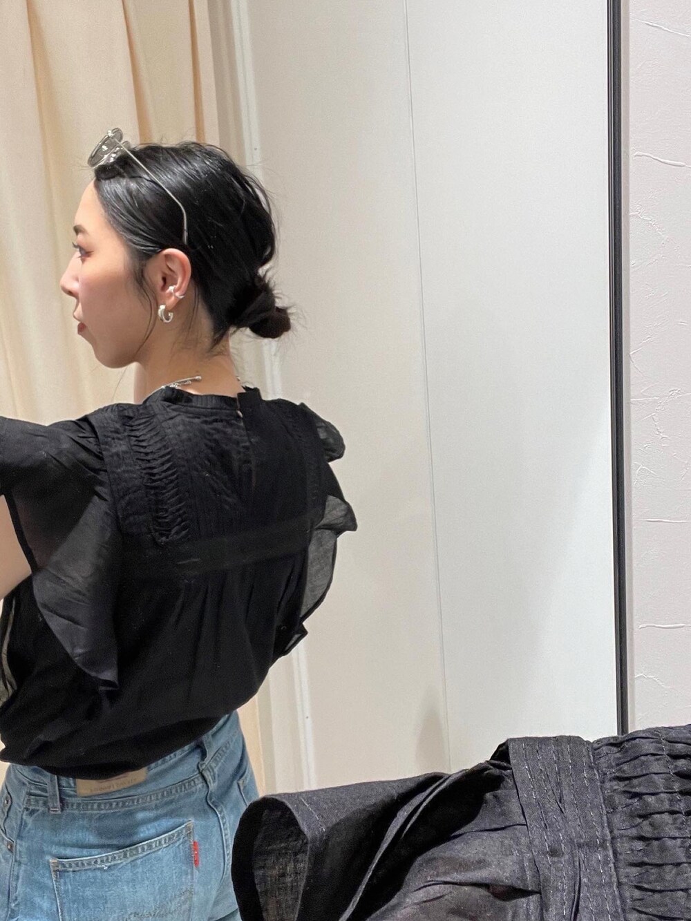 ブラック系のサンダル、ブルー系のデニムパンツ、ブラック系のシャツ/ブラウスを着用したレディースの春コーディネートの5枚目の写真