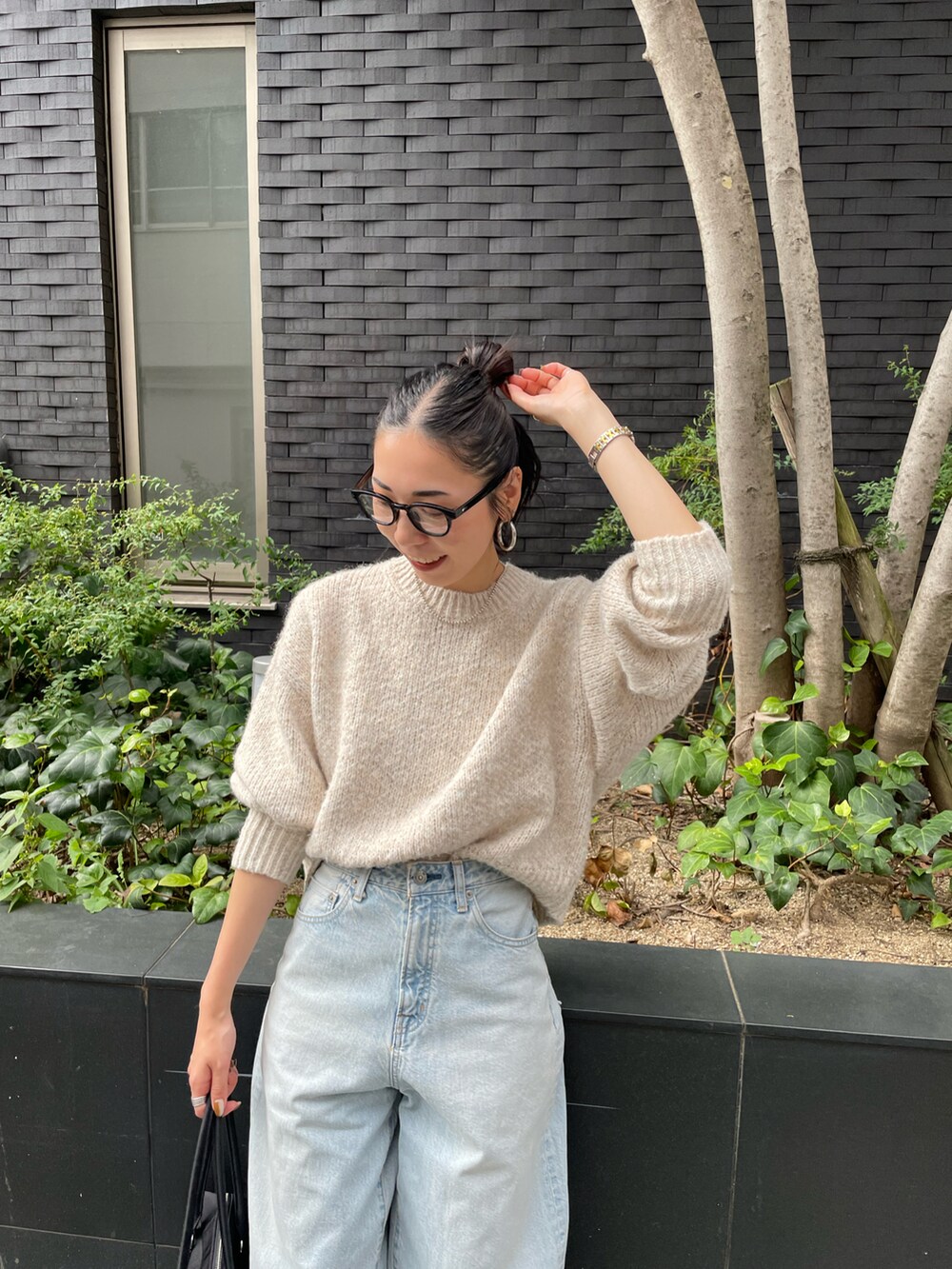 ブルー系のデニムパンツ、ホワイト系のニット/セーター、ブラック系のスニーカーを着用したレディースの秋コーディネートの4枚目の写真