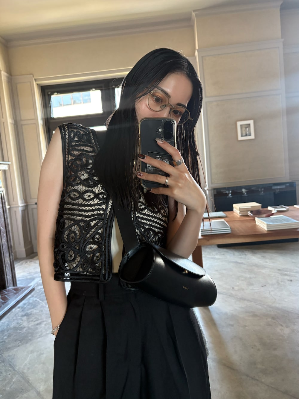 ブラック系のサンダル、ブラック系のスラックス、ブラック系のベストを着用したレディースの夏コーディネートの4枚目の写真