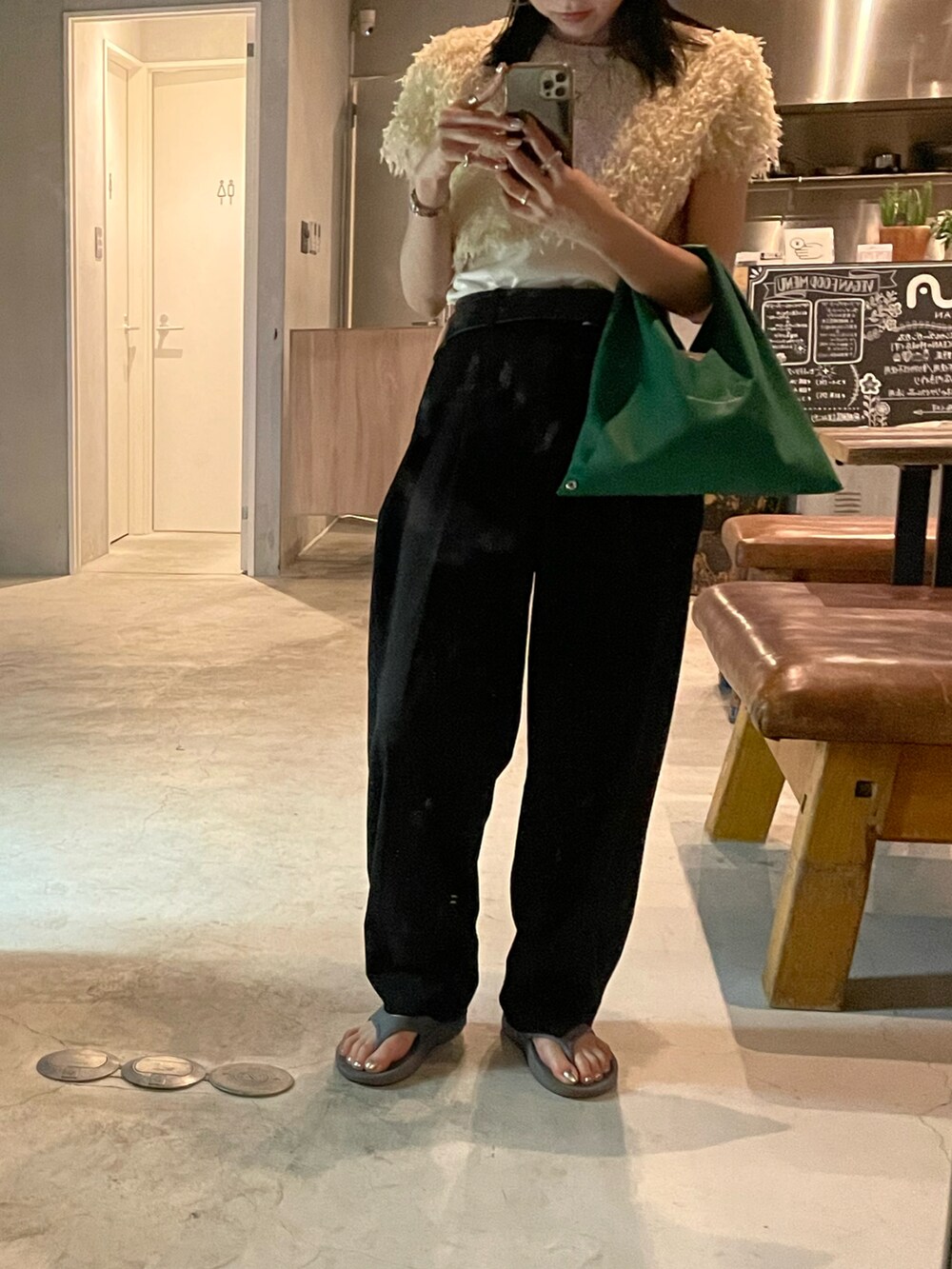 ブラック系のスラックス、グリーン系のショルダーバッグ、ホワイト系のTシャツ/カットソーを着用したレディースの春コーディネートの5枚目の写真