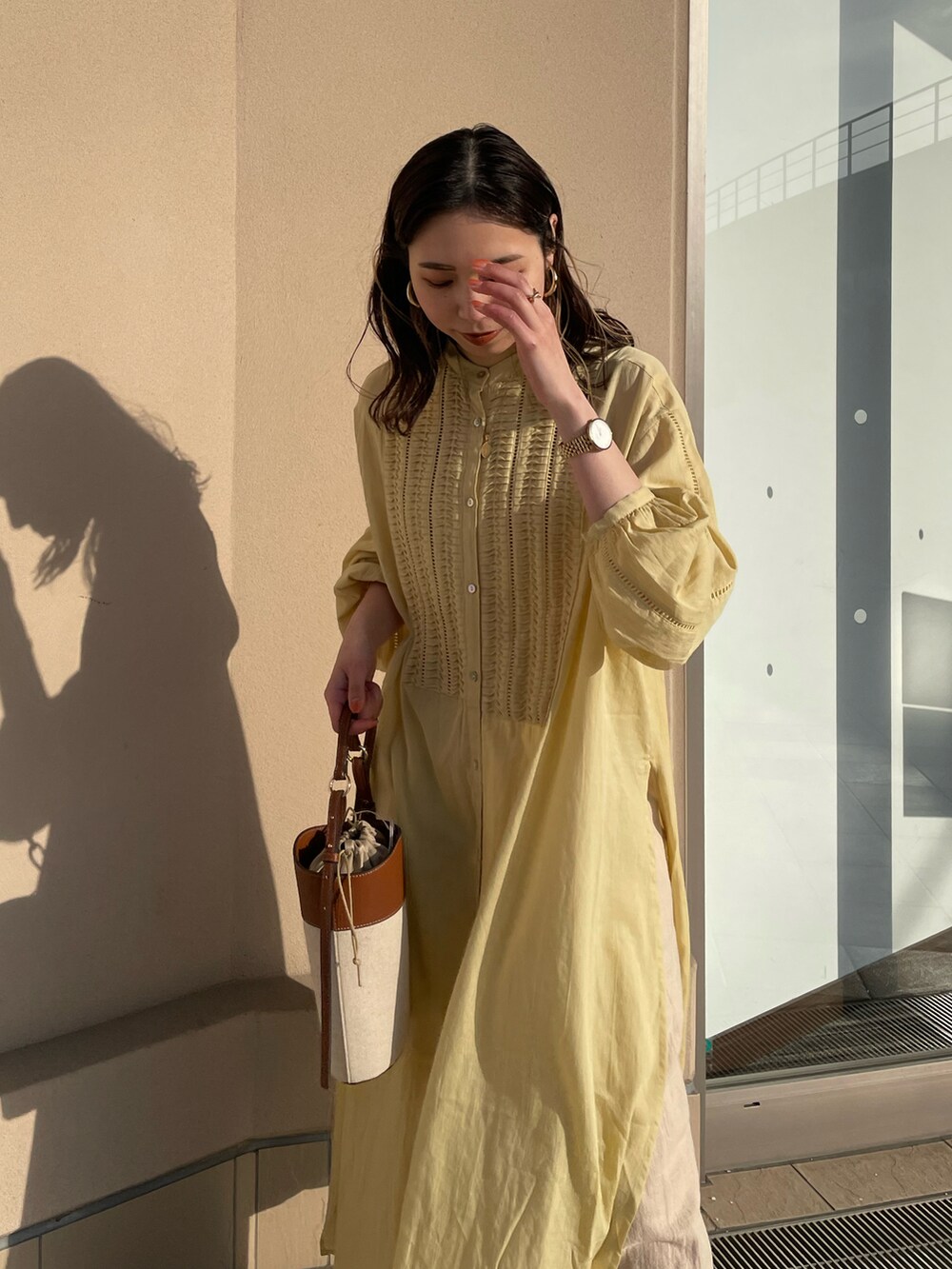 イエロー系のワンピース、ホワイト系のその他パンツ、ブラウン系のショルダーバッグを着用したレディースの春コーディネートの3枚目の写真