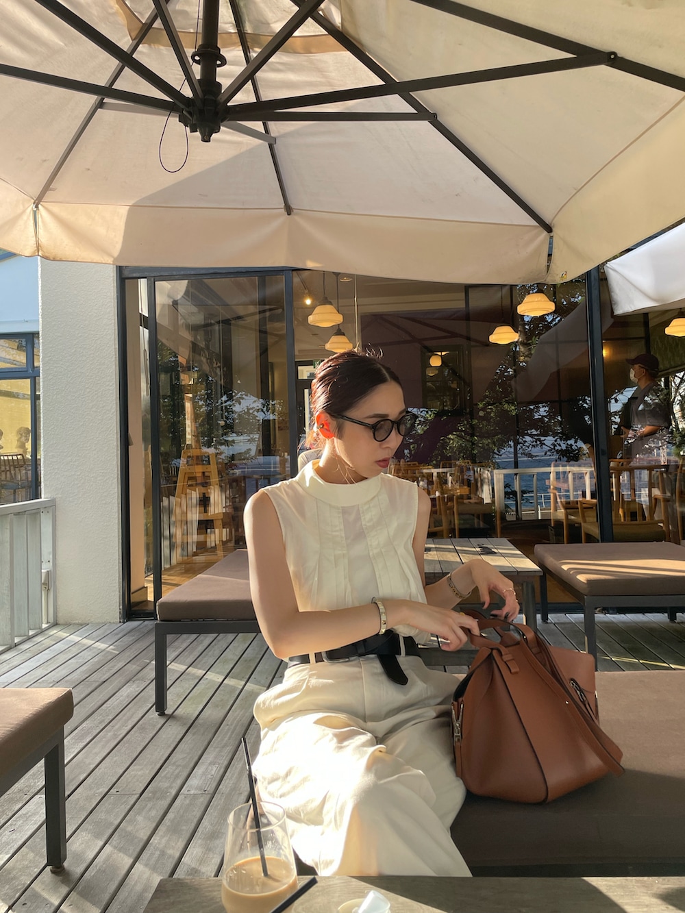 ブラウン系のバックパック/リュック、ホワイト系のシャツ/ブラウス、ブラウン系のサンダルを着用したレディースの夏コーディネートの5枚目の写真