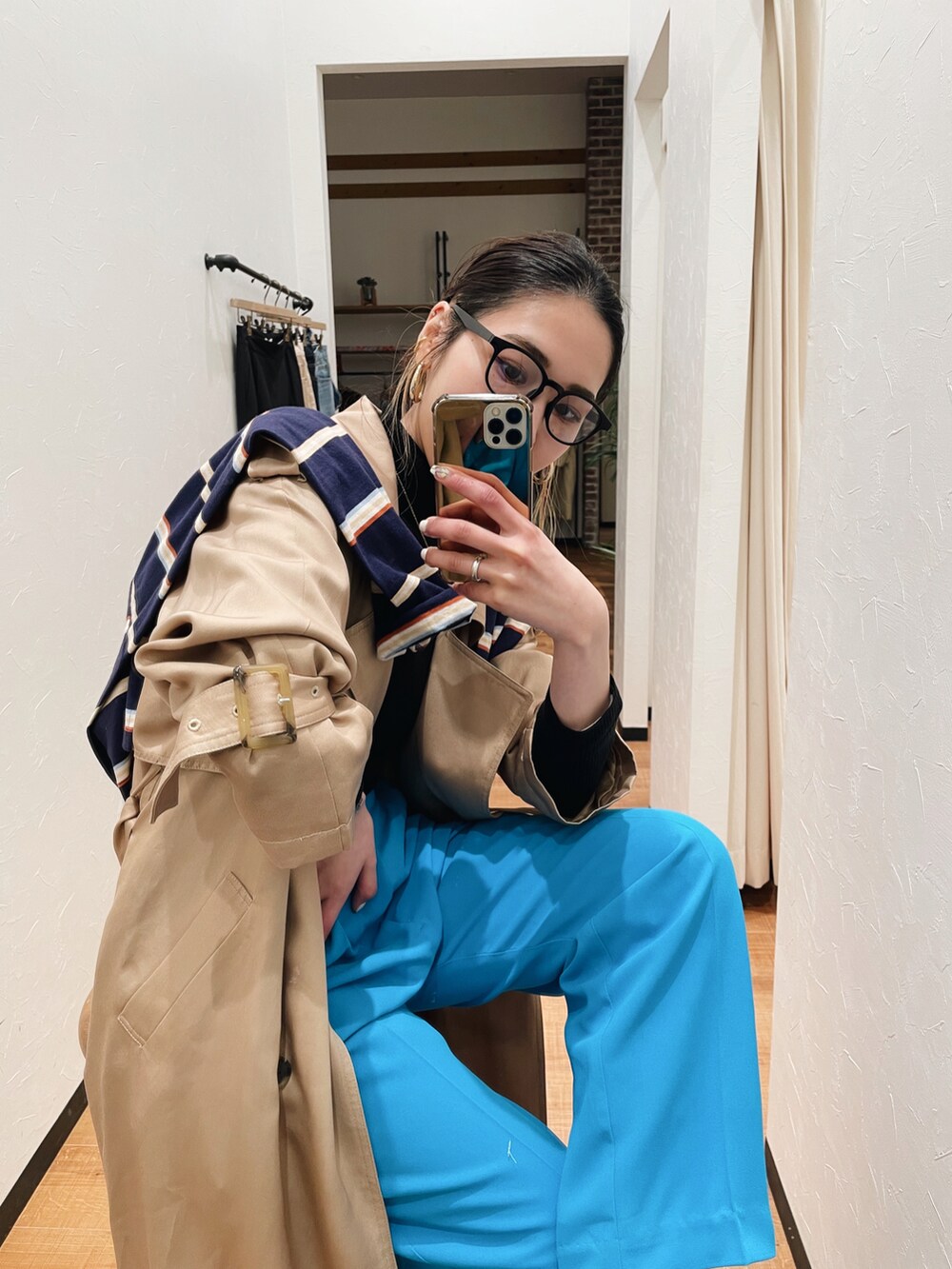 ブルー系のスラックス、ベージュ系のトレンチコート、ブルー系のTシャツ/カットソーを着用したレディースの冬コーディネートの3枚目の写真