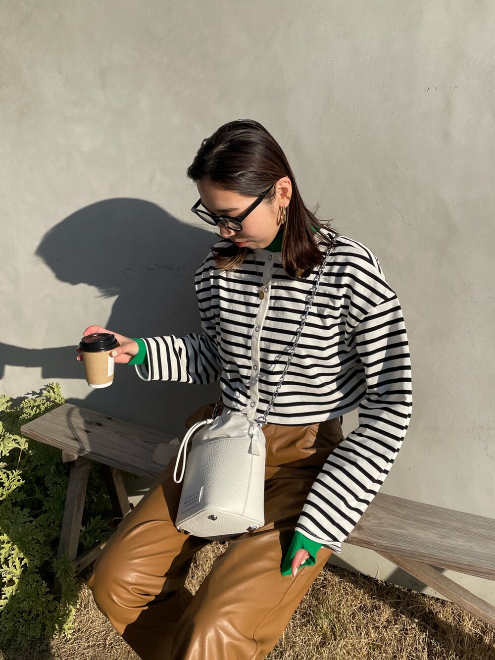 ブラック系のTシャツ/カットソー、ブラウン系のその他パンツ、ホワイト系のショルダーバッグを着用したレディースの冬コーディネートの3枚目の写真