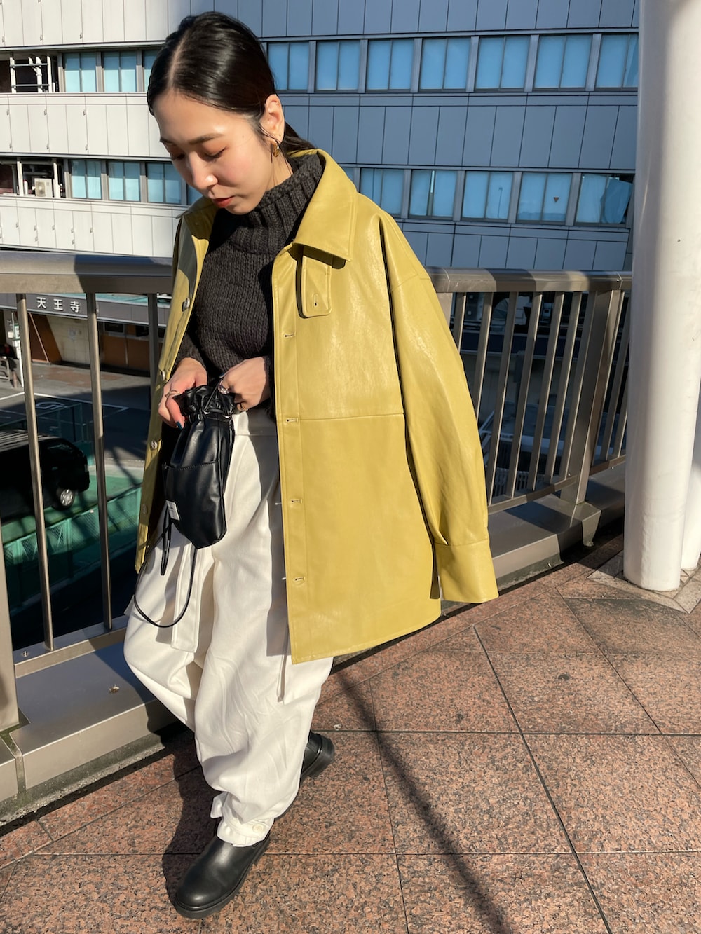 ブラック系のショルダーバッグ、ブラック系のブーツ、ホワイト系のカーゴパンツを着用したレディースの秋コーディネートの2枚目の写真