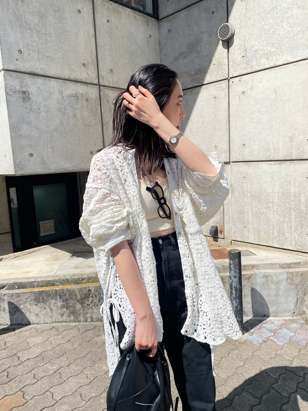 ホワイト系のキャミソール、ブラック系のデニムパンツ、ホワイト系のシャツ/ブラウスを着用したレディースの春コーディネートの4枚目の写真