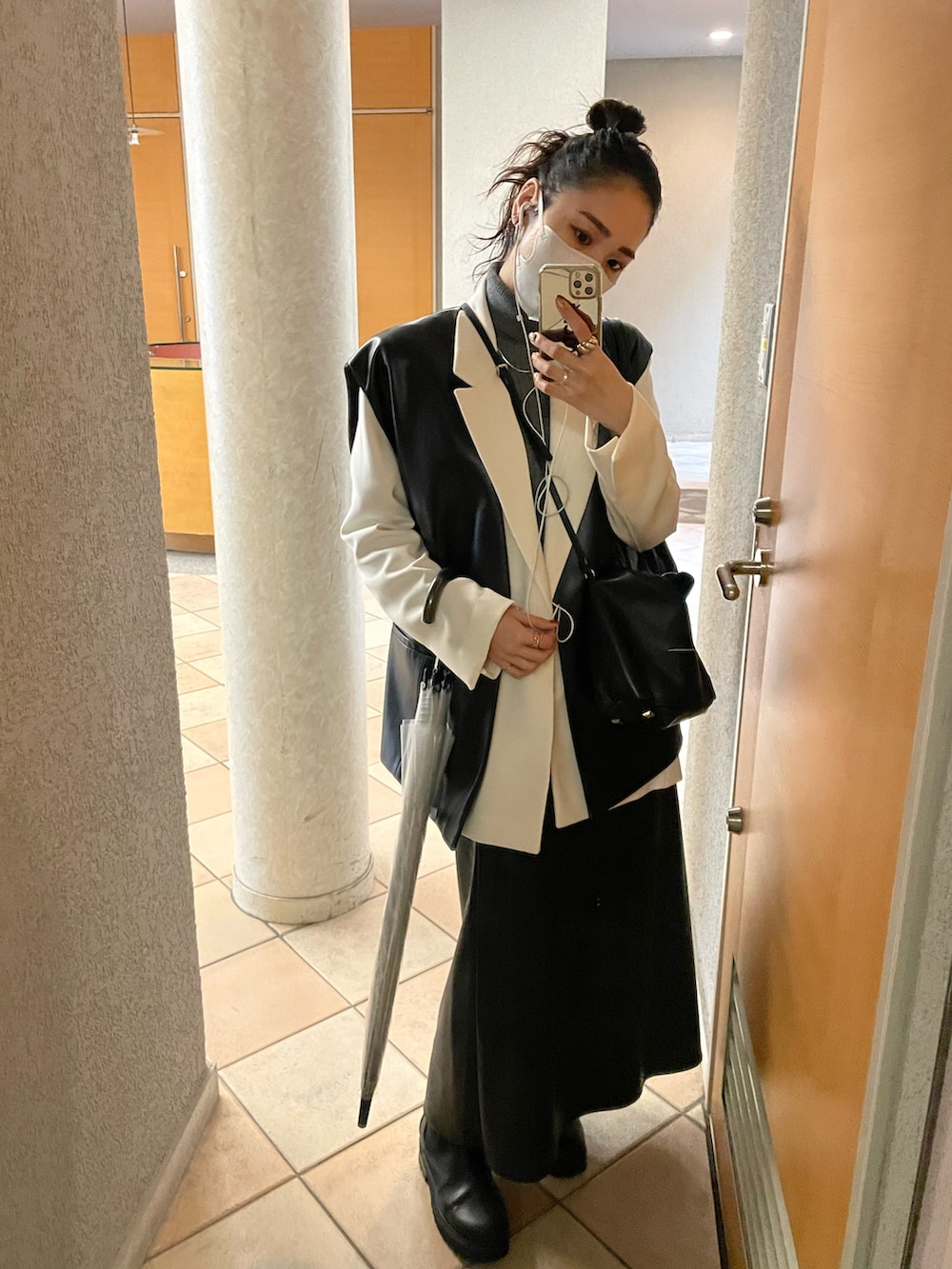 ホワイト系のテーラードジャケット、ブラック系のショルダーバッグ、ブラック系のスカートを着用したレディースの秋コーディネートの3枚目の写真