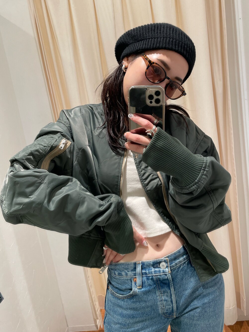 ブルー系のデニムパンツ、ベージュ系のMA-1、ブラック系のハンチング/ベレー帽を着用したレディースの秋コーディネートの3枚目の写真