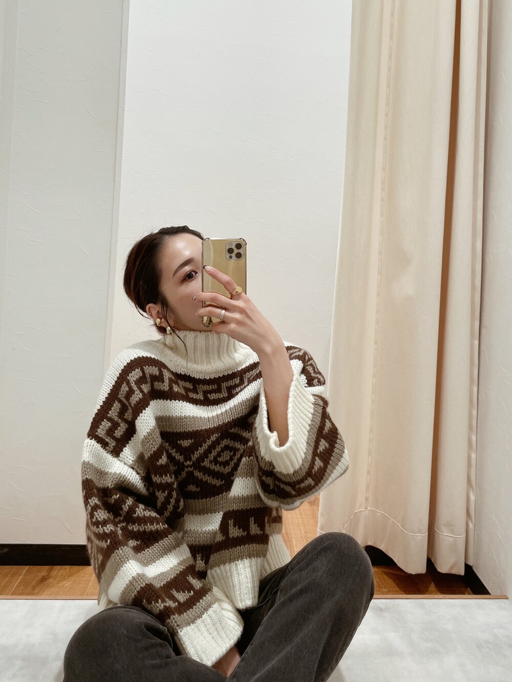 ホワイト系のニット/セーター、ブラック系のデニムパンツを着用したレディースの秋コーディネートの2枚目の写真