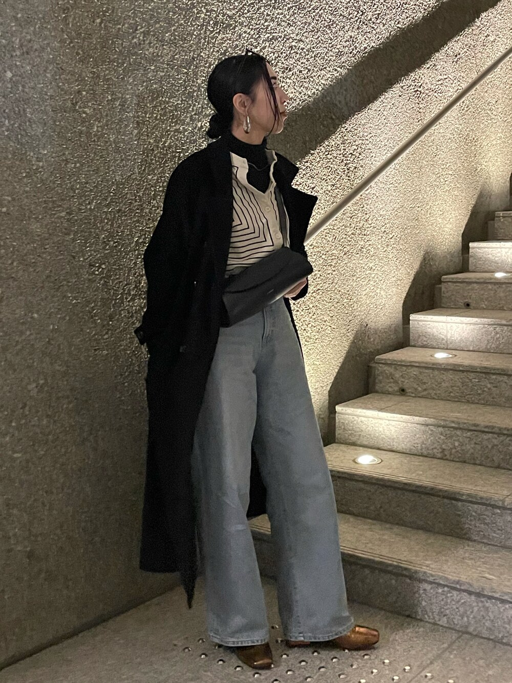 ブラック系のチェスターコート、ホワイト系のシャツ/ブラウス、ゴールド系のパンプスを着用したレディースの春コーディネートの3枚目の写真