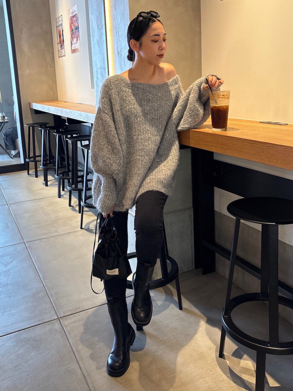 ブラック系のショルダーバッグ、ブラック系のブーツ、ブラック系のデニムパンツを着用したレディースの秋コーディネートの4枚目の写真