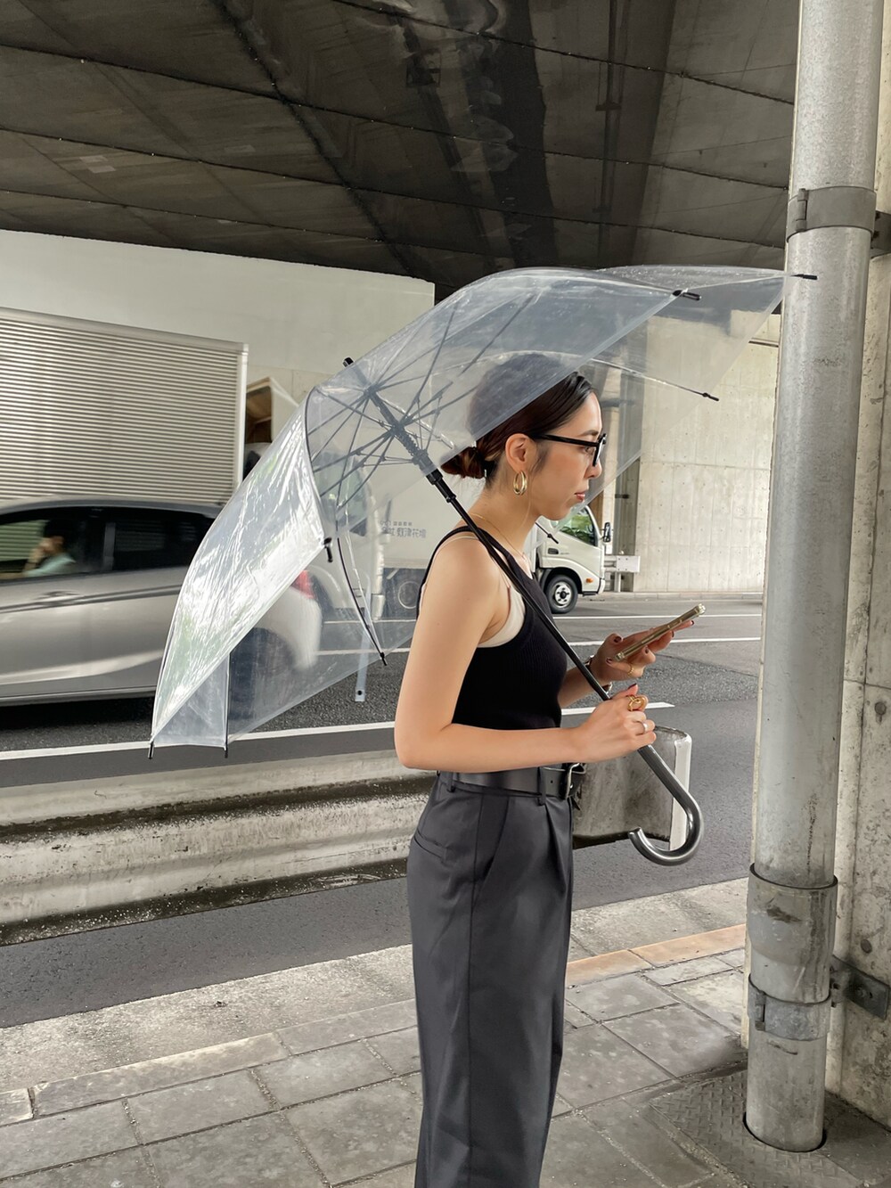 グレー系のスラックス、ブラック系のタンクトップ、ブラック系のベルトを着用したレディースの夏コーディネートの4枚目の写真