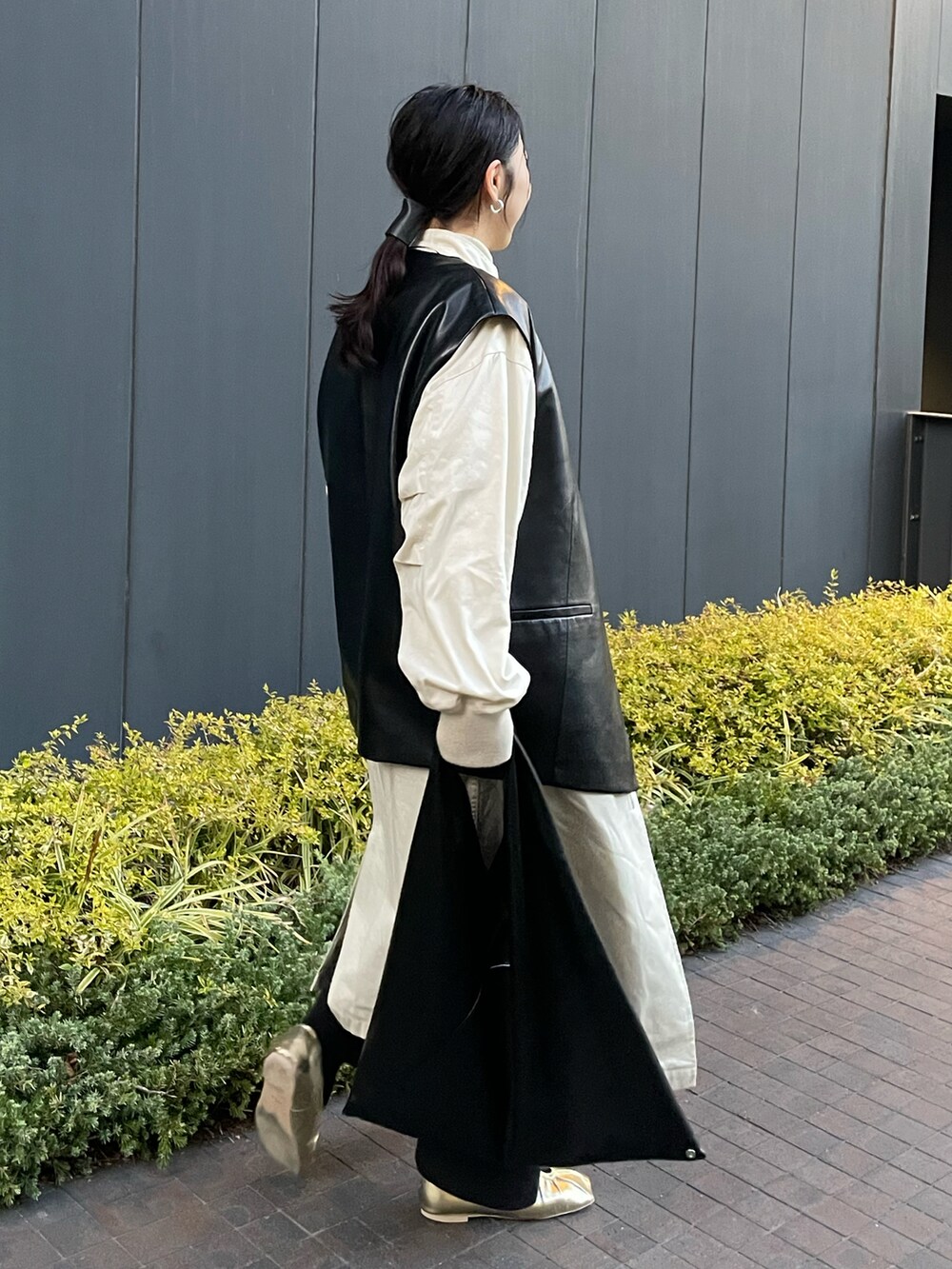 ブラック系のジャケット/アウター、ホワイト系のその他アウター、ブラック系のハンドバッグを着用したレディースの春コーディネートの2枚目の写真