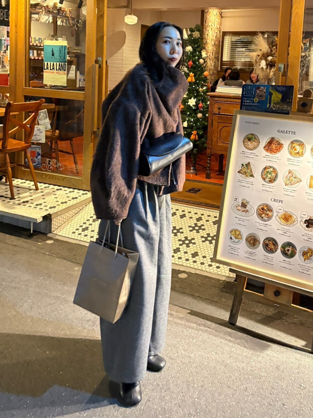 ブラウン系のその他アウター、ブラック系のショルダーバッグ、ブラック系のブーツを着用したレディースの秋コーディネートの2枚目の写真