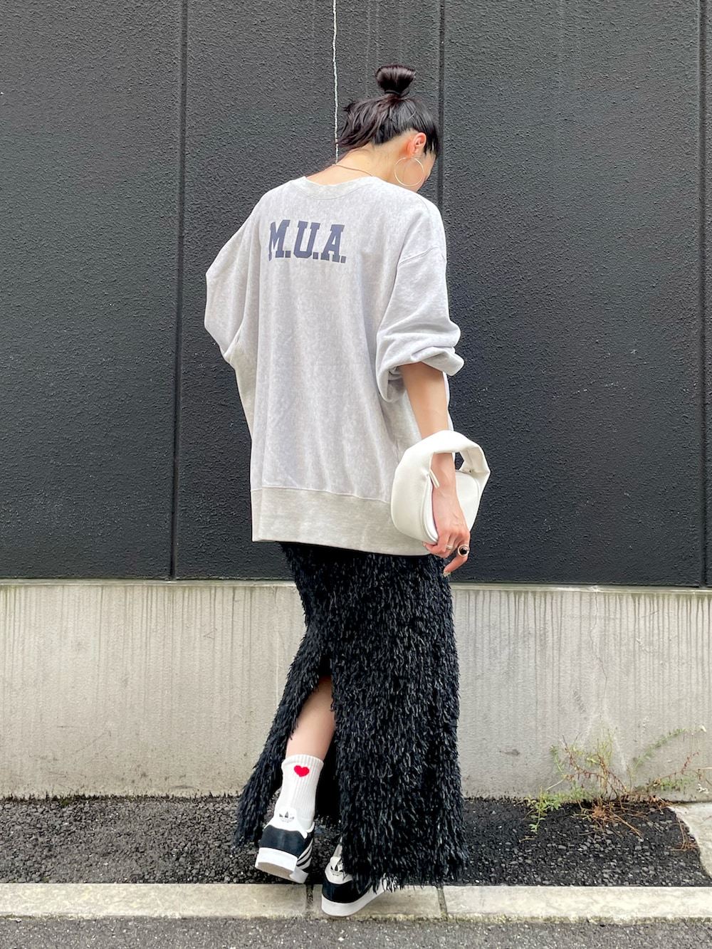 ブラック系のスカート、グレー系のスウェット、ブラック系のスニーカーを着用したレディースの秋コーディネートの2枚目の写真