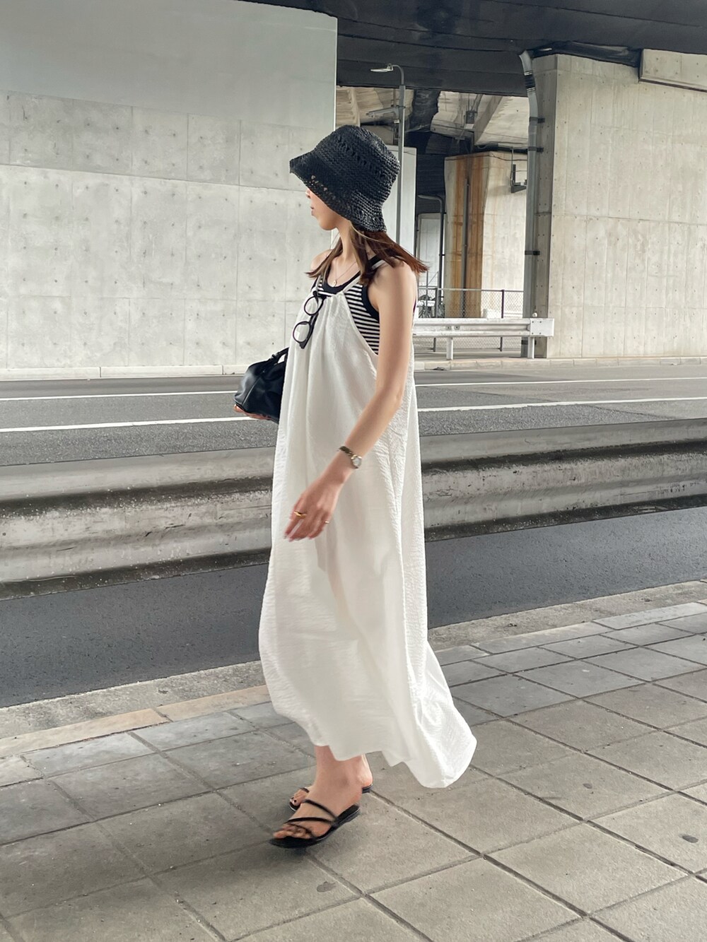 ホワイト系のタンクトップ、ホワイト系のワンピース、ブラック系のハンドバッグを着用したレディースの夏コーディネートの2枚目の写真
