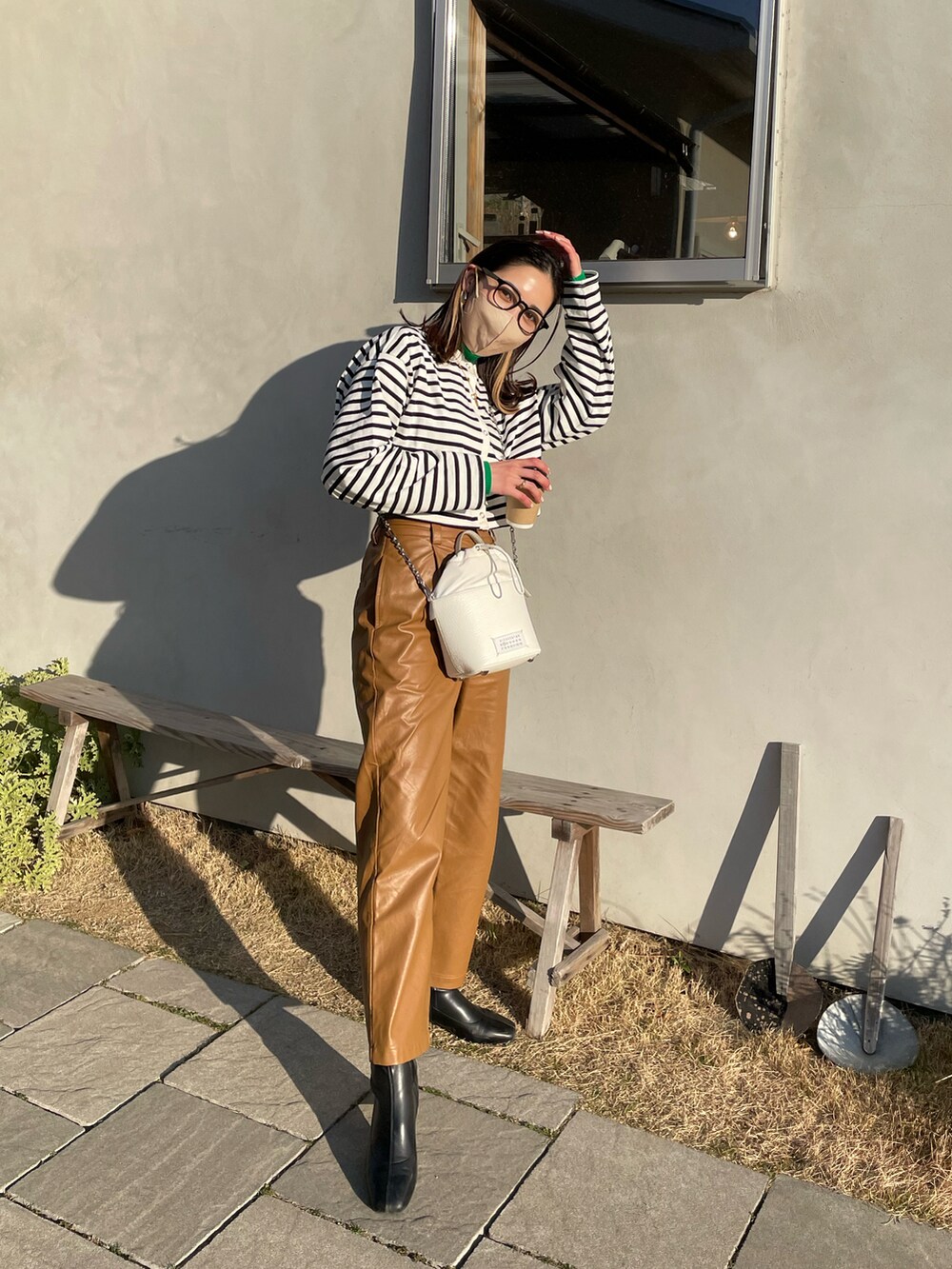 ブラック系のTシャツ/カットソー、ブラウン系のその他パンツ、ホワイト系のショルダーバッグを着用したレディースの冬コーディネートの5枚目の写真