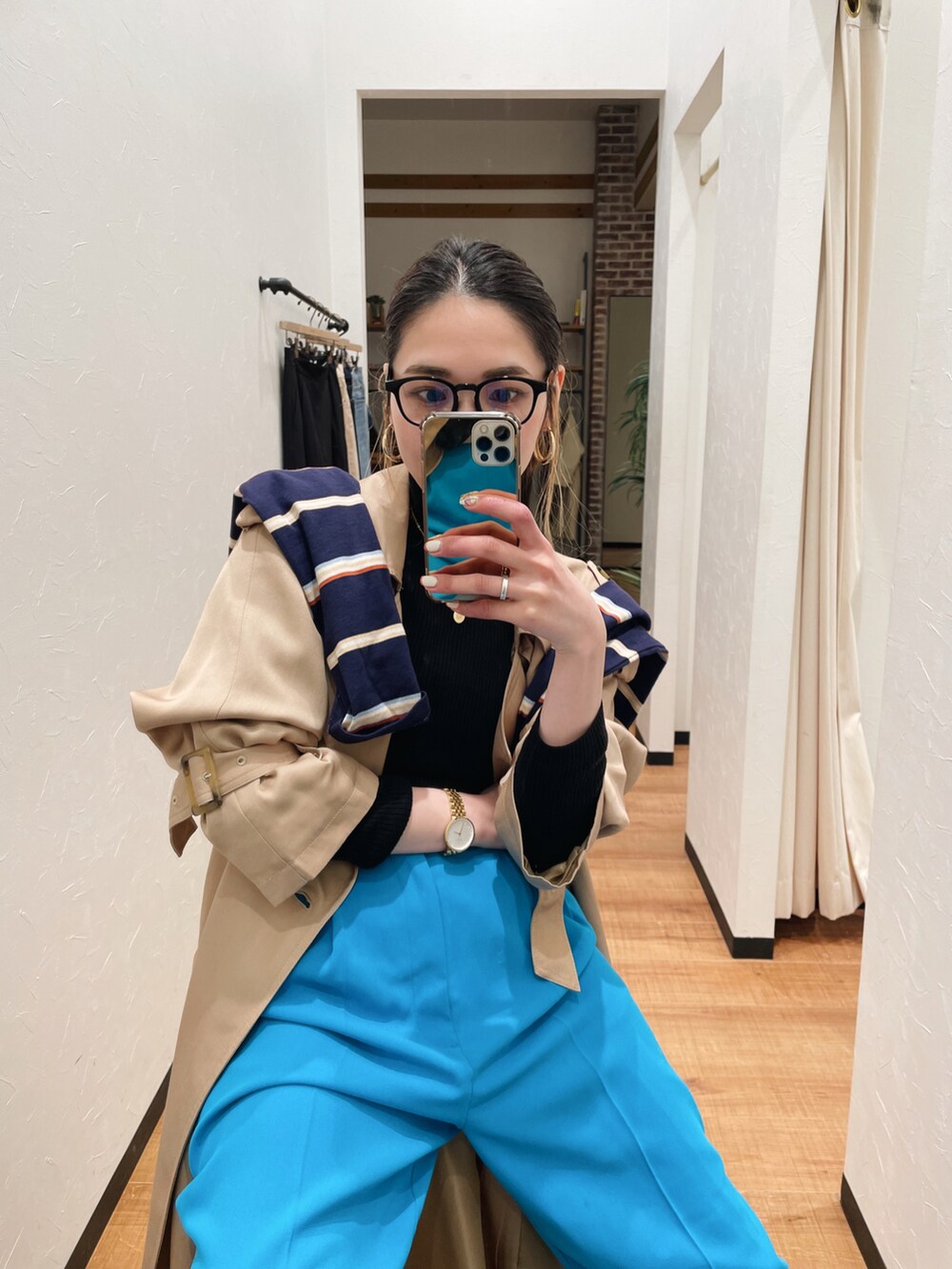 ブルー系のスラックス、ベージュ系のトレンチコート、ブルー系のTシャツ/カットソーを着用したレディースの冬コーディネートの4枚目の写真