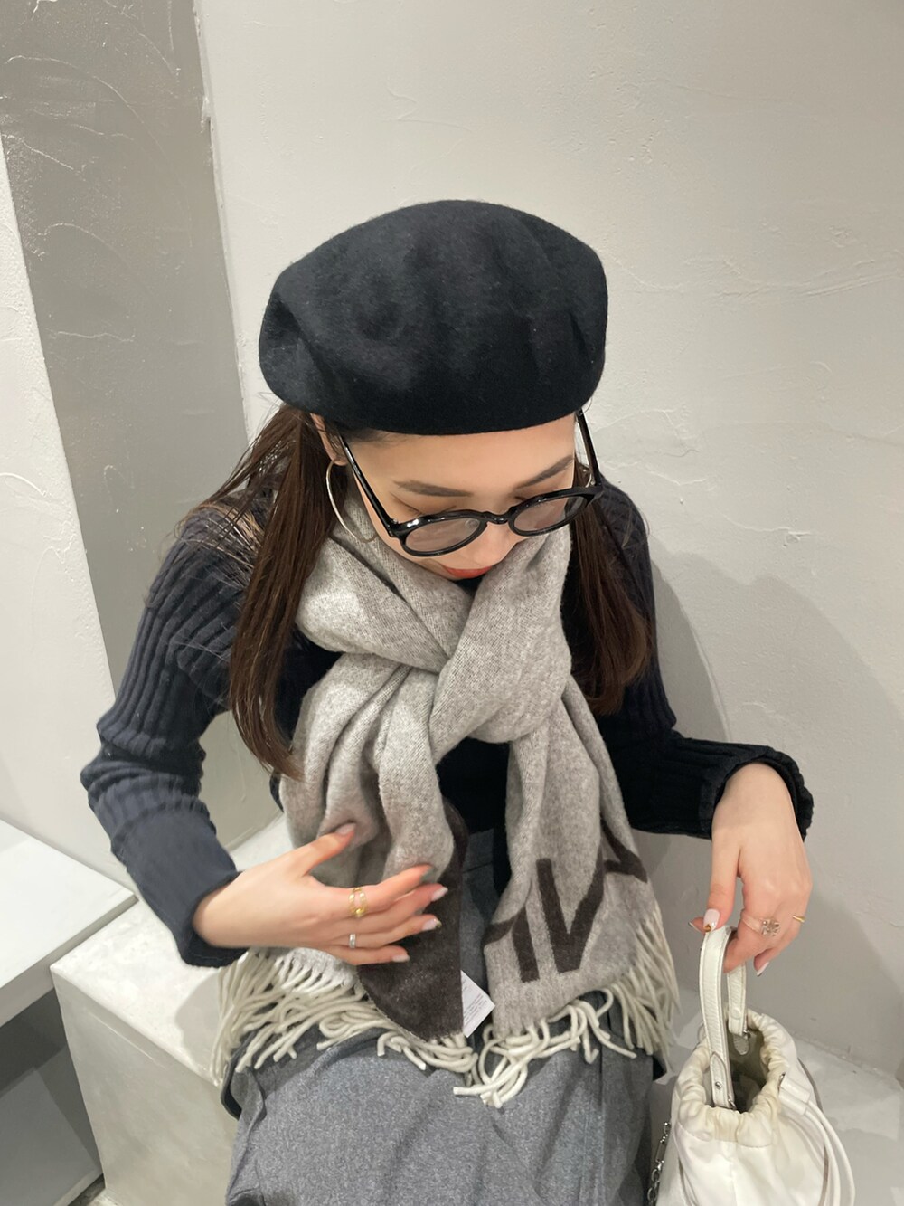 ホワイト系のショルダーバッグ、グレー系のカーゴパンツ、ブラック系のブーツを着用したレディースの冬コーディネートの4枚目の写真